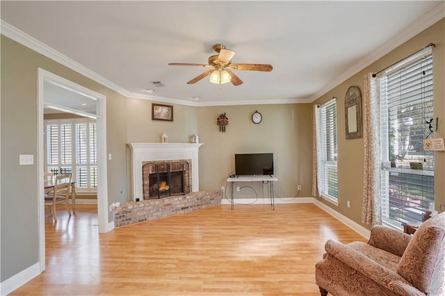 living room featuring a fireplace, a wealth of natural light, light hardwood / wood-style flooring, and ceiling fan