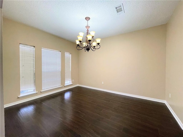 unfurnished room featuring a chandelier, a textured ceiling, and hardwood / wood-style flooring