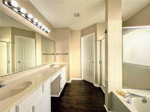 bathroom with hardwood / wood-style floors, vanity, a textured ceiling, and independent shower and bath