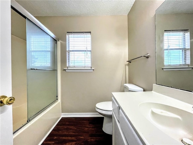 full bathroom with shower / bath combination with glass door, vanity, a textured ceiling, and hardwood / wood-style flooring