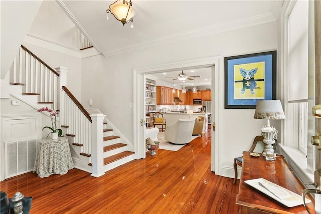 interior space with dark hardwood / wood-style flooring, ceiling fan, and crown molding