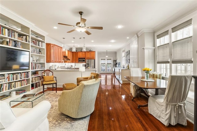 living room with dark hardwood / wood-style floors, plenty of natural light, crown molding, and ceiling fan