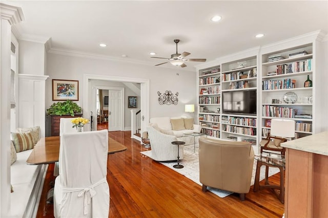 living area featuring dark hardwood / wood-style floors, ceiling fan, and crown molding