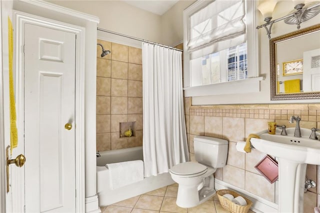 full bathroom featuring sink, tile patterned flooring, toilet, shower / bath combo with shower curtain, and tile walls