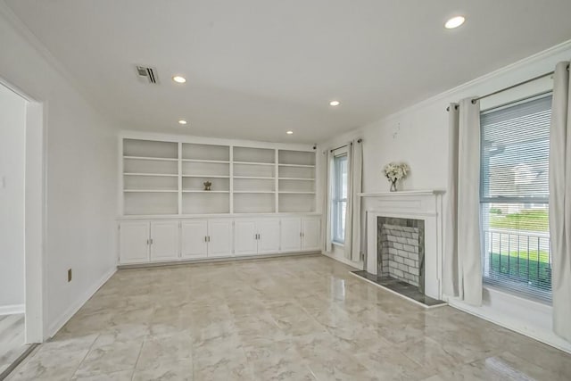 unfurnished living room with plenty of natural light, built in features, and ornamental molding