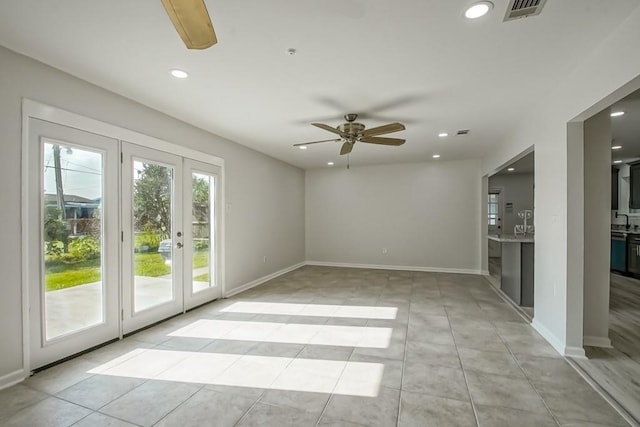 tiled spare room with ceiling fan, french doors, and sink