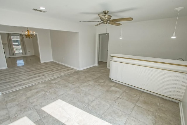 empty room with ceiling fan with notable chandelier