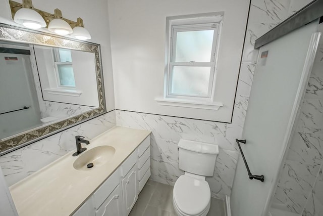 bathroom featuring vanity, toilet, and tile walls