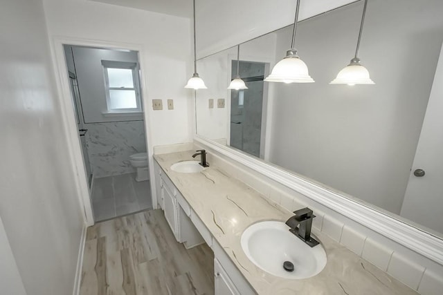 bathroom featuring vanity, toilet, walk in shower, tile walls, and wood-type flooring