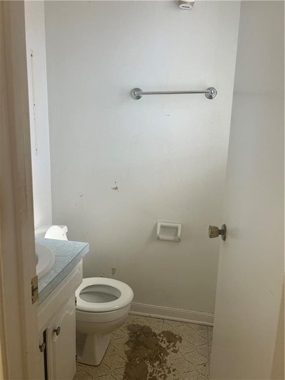 bathroom with toilet, vanity, and tile patterned floors