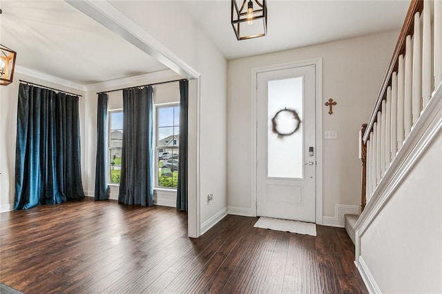 foyer with dark hardwood / wood-style floors and a notable chandelier