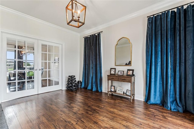 interior space with french doors, a chandelier, dark hardwood / wood-style floors, and ornamental molding