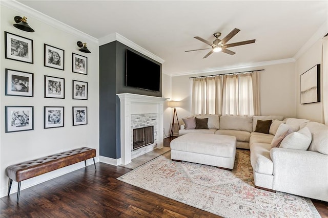 living room with dark hardwood / wood-style floors, ceiling fan, crown molding, and a tiled fireplace