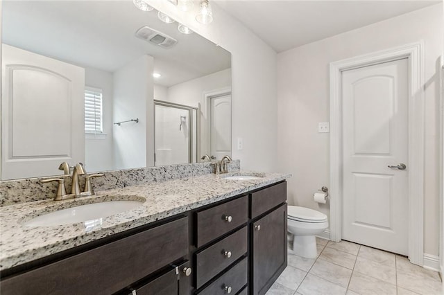 bathroom featuring tile patterned flooring, vanity, toilet, and a shower with door