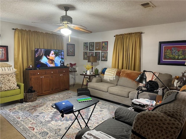 living room featuring ceiling fan and a textured ceiling