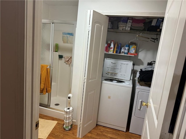 laundry area with washing machine and clothes dryer and light wood-type flooring