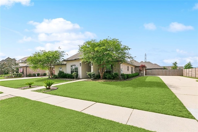 view of front of house with a front lawn, driveway, stucco siding, and fence