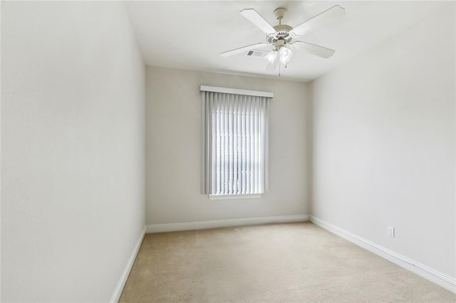 empty room with ceiling fan, light colored carpet, and baseboards
