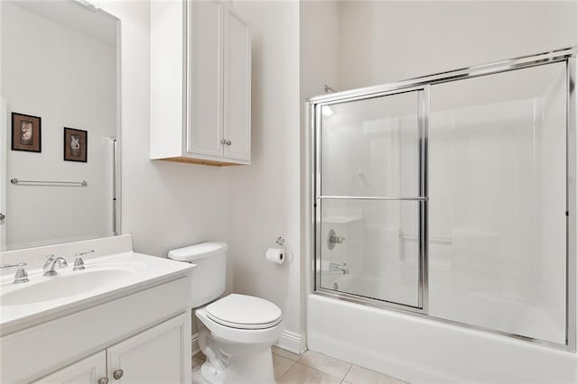 full bath with tile patterned floors, vanity, toilet, and shower / bath combination with glass door