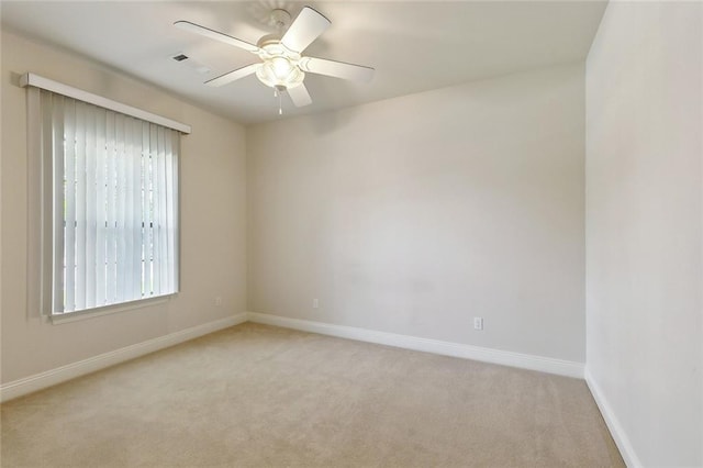 empty room with visible vents, baseboards, and light carpet