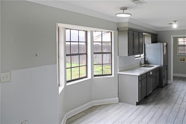 kitchen featuring stainless steel fridge, gray cabinets, crown molding, and light hardwood / wood-style flooring