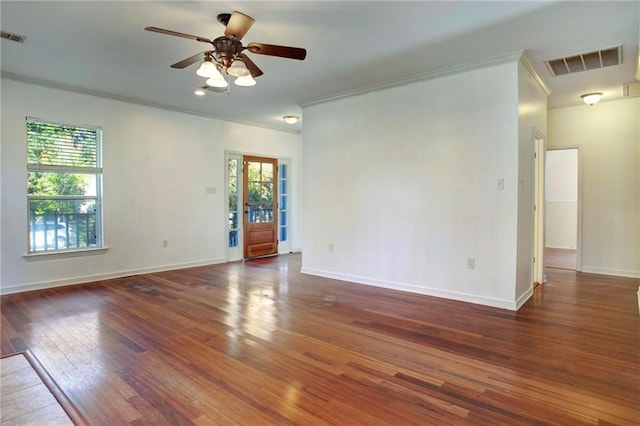 empty room featuring ceiling fan, crown molding, and dark hardwood / wood-style floors