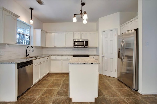 kitchen with pendant lighting, a kitchen island, stainless steel appliances, and sink