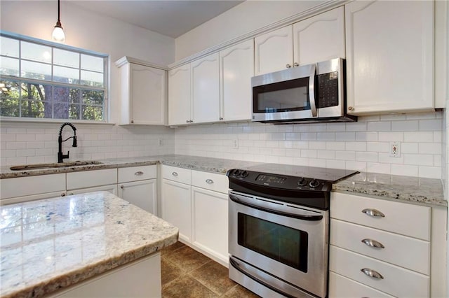 kitchen with white cabinets, sink, decorative backsplash, light stone countertops, and stainless steel appliances