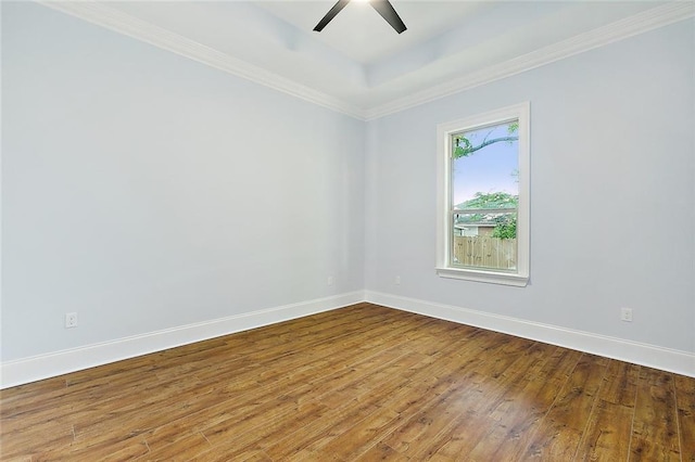 spare room with ceiling fan, baseboards, a raised ceiling, and hardwood / wood-style floors