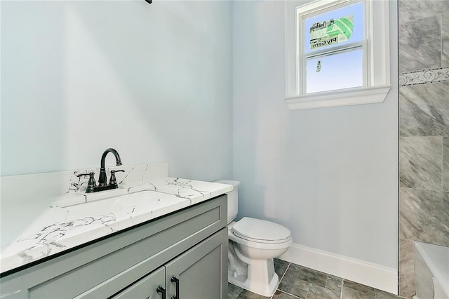 full bath with toilet, baseboards, tiled shower, and vanity