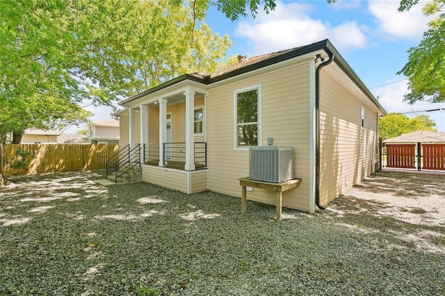 view of property exterior featuring fence and central AC unit