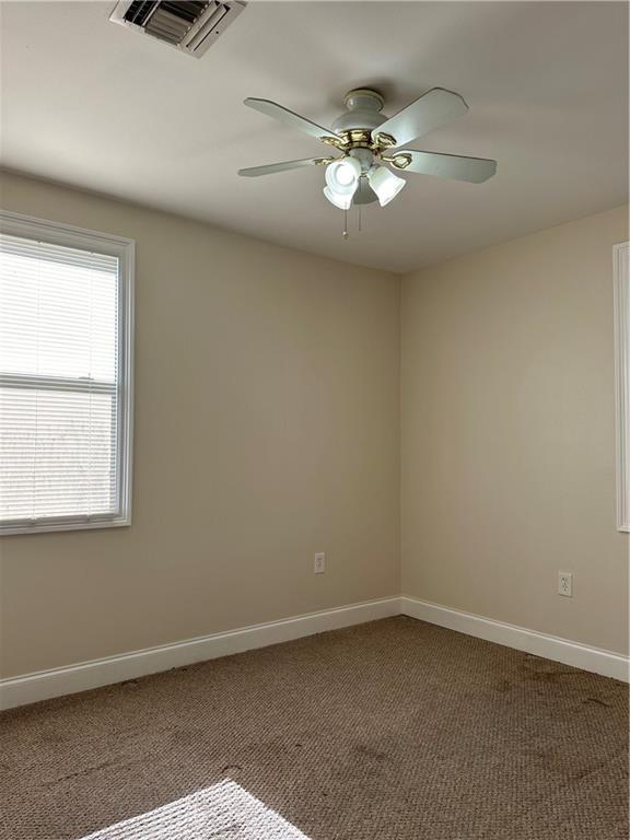 unfurnished room featuring ceiling fan and carpet