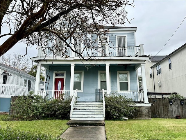 view of front facade with a front yard and a balcony