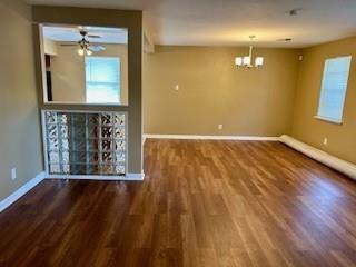 unfurnished room featuring ceiling fan with notable chandelier and wood-type flooring