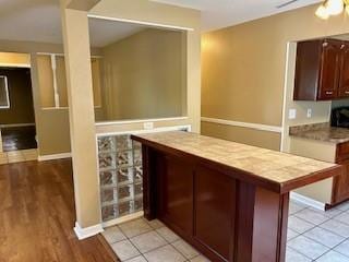 bar featuring ceiling fan and light hardwood / wood-style flooring