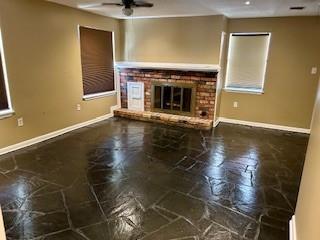 unfurnished living room with a fireplace and ceiling fan