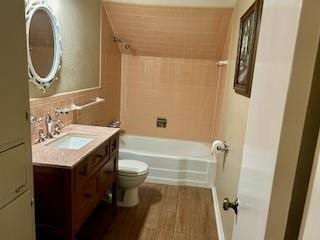 full bathroom featuring vanity, hardwood / wood-style flooring, toilet, and tiled shower / bath combo