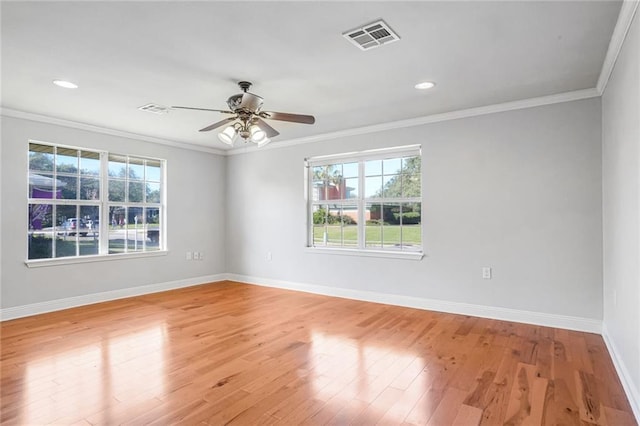 unfurnished room with ornamental molding, a wealth of natural light, and light hardwood / wood-style flooring