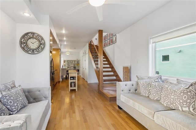 living room with light hardwood / wood-style floors and ceiling fan