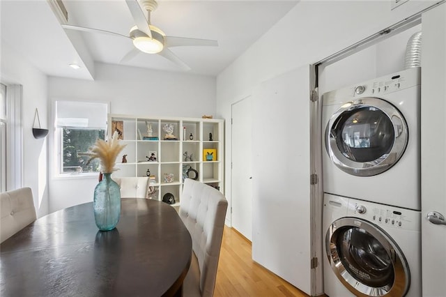 laundry area with light hardwood / wood-style floors, stacked washer / dryer, and ceiling fan