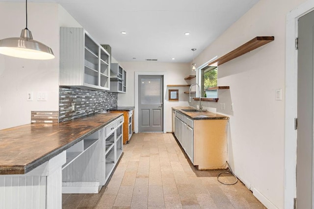 kitchen featuring backsplash, hanging light fixtures, and sink