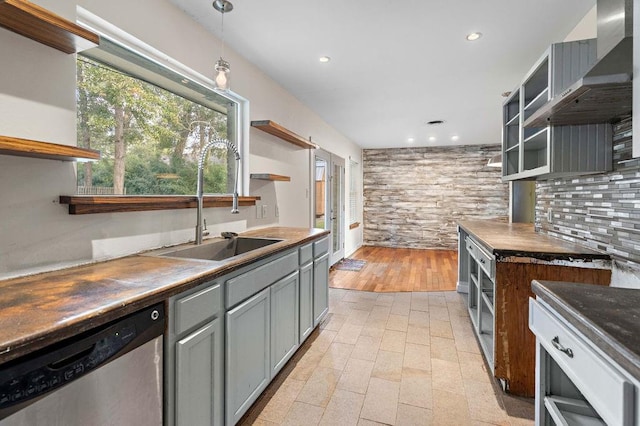 kitchen with sink, wall chimney range hood, stainless steel dishwasher, decorative light fixtures, and gray cabinets