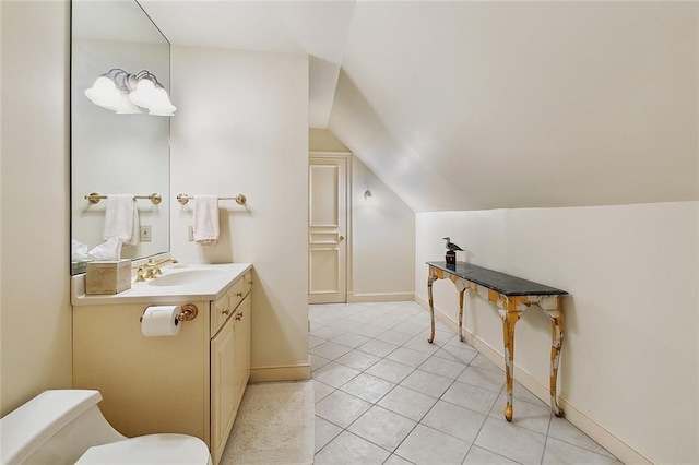 3832 Edenborn Ave, Metairie, LA 70002 - bathroom with vanity, toilet, vaulted ceiling, tile patterned floors, and baseboards