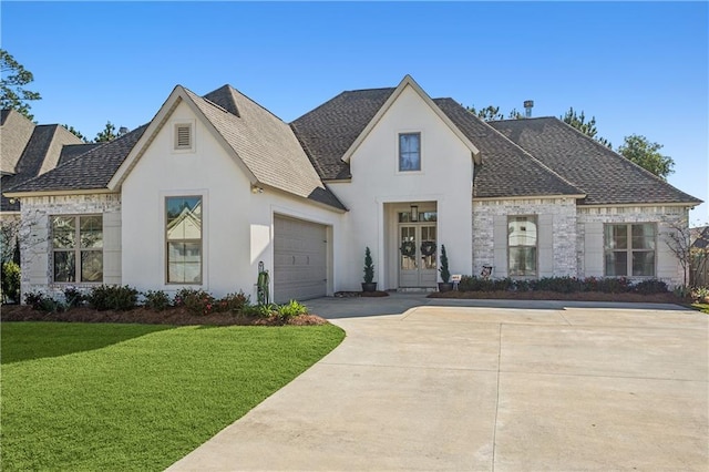 french provincial home featuring a garage and a front lawn