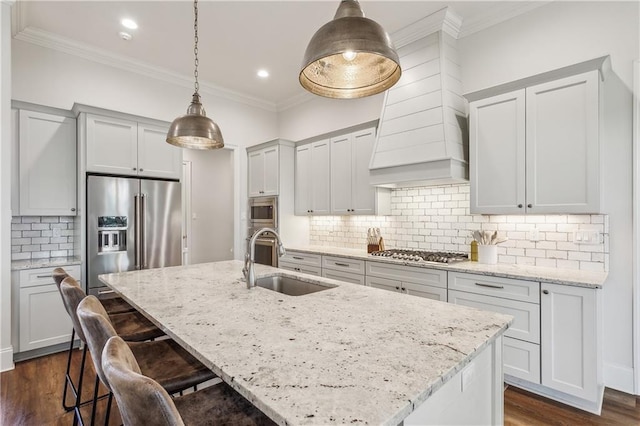 kitchen featuring a kitchen island with sink, sink, decorative backsplash, decorative light fixtures, and stainless steel appliances