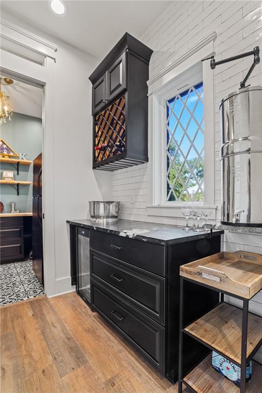 kitchen featuring black fridge, beverage cooler, and light hardwood / wood-style flooring