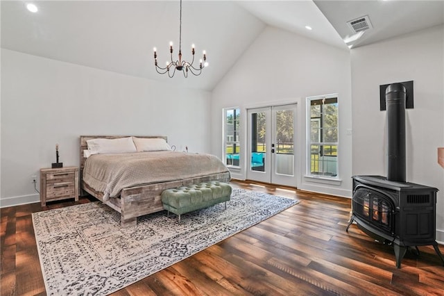 bedroom featuring high vaulted ceiling, a wood stove, access to exterior, dark wood-type flooring, and french doors