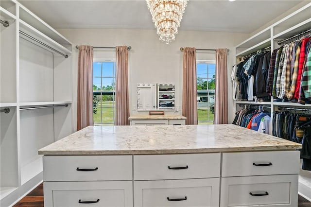 spacious closet featuring a notable chandelier