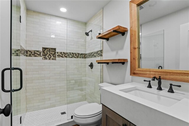 bathroom featuring walk in shower, vanity, and toilet