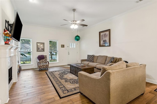 living room featuring hardwood / wood-style floors, ceiling fan, and crown molding